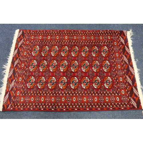 547 - Turkoman rug, the red field decorated with three rows of eight guls, 148cm x 100cm. 