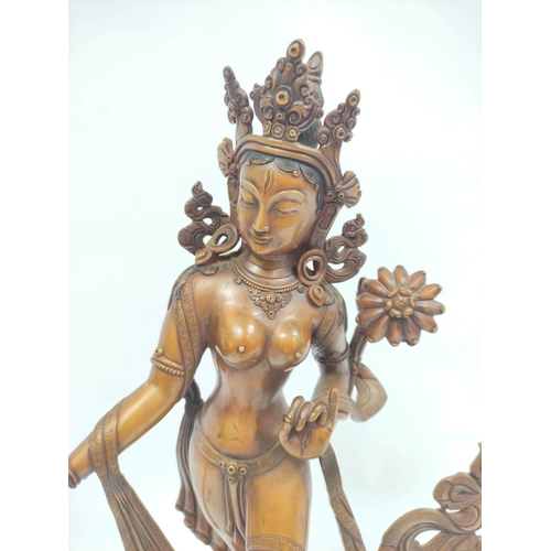 360 - Sino-Tibetan patinated bronze figure of a female deity standing on oval lotus plinth base, 39cm high... 