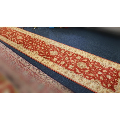 551 - Ziegler style runner, the red field with scrolling floral design framed by cream border, fringed end... 