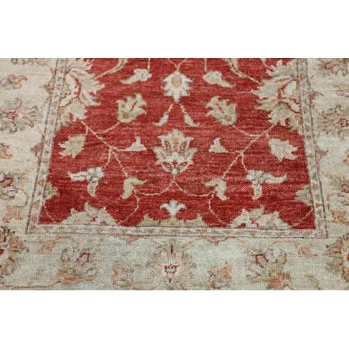 551 - Ziegler style runner, the red field with scrolling floral design framed by cream border, fringed end... 