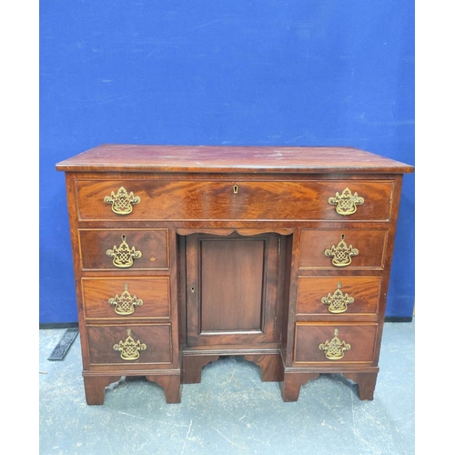 431 - Mahogany kneehole desk in the early Georgian style, a long drawer above central cupboard door flanke... 