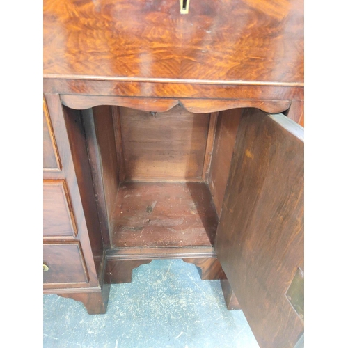 431 - Mahogany kneehole desk in the early Georgian style, a long drawer above central cupboard door flanke... 