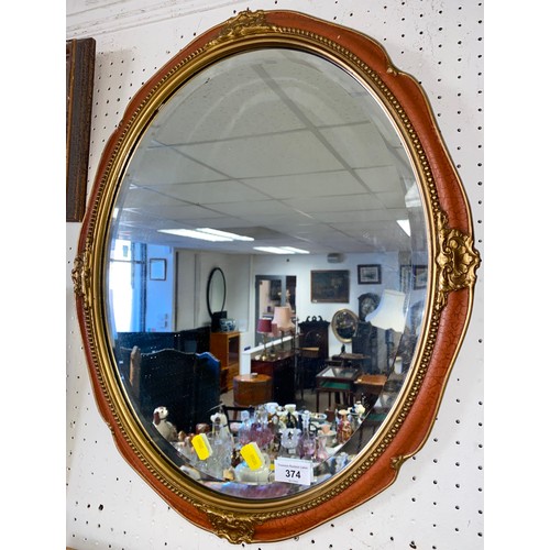 374 - Oval framed bevel edged red and gilt wall mirror