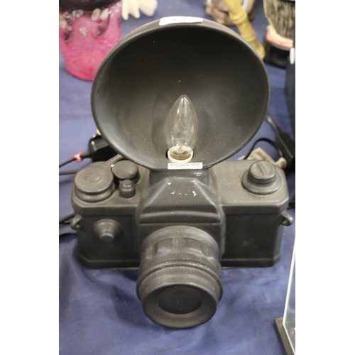 126 - Novelty table lamp in the form of a camera, 31cm high.