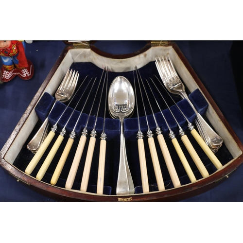 134 - Edwardian canteen of cutlery, in shaped mahogany box.