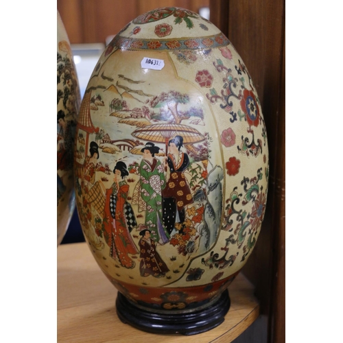 79 - Large oriental style egg shaped ornament, on stand, and another.