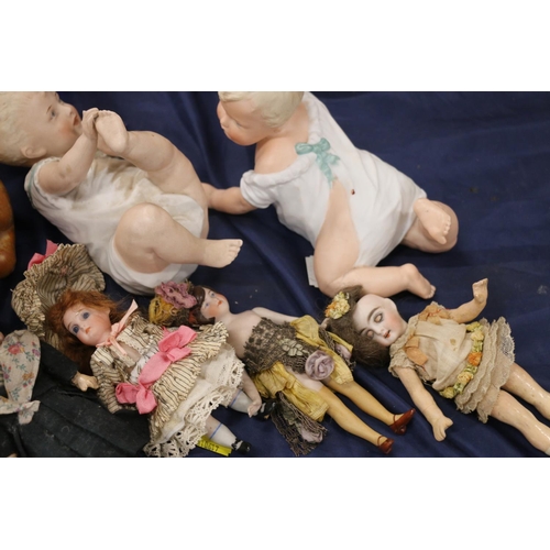 94 - Two bisque porcelain piano dolls, and six small bisque headed dolls.