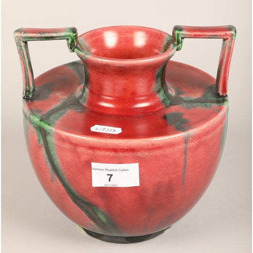 7 - Twin handled red glazed vase, impressed mark M H on base, 19 cm high