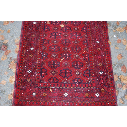 328 - Afghan Belouch hand-knotted rug with geometric guls to the centre flanked by further geometric motif... 