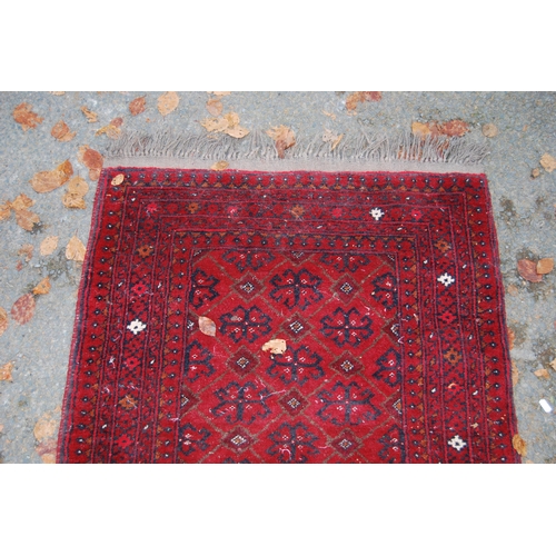 328 - Afghan Belouch hand-knotted rug with geometric guls to the centre flanked by further geometric motif... 