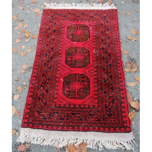 329 - Afghan Belouch hand-knotted rug with three large geometric guls to the centre and further geometric ... 