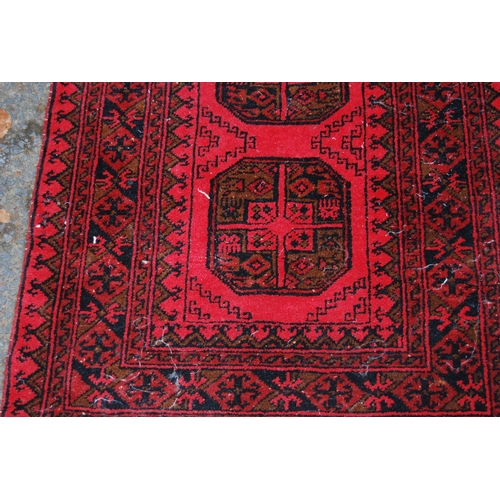 329 - Afghan Belouch hand-knotted rug with three large geometric guls to the centre and further geometric ... 