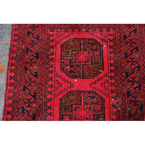 329 - Afghan Belouch hand-knotted rug with three large geometric guls to the centre and further geometric ... 