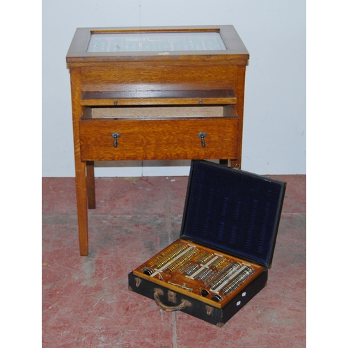 375 - Vintage oak optician's cabinet with glazed viewing top enclosing lenses in fitted compartments above... 