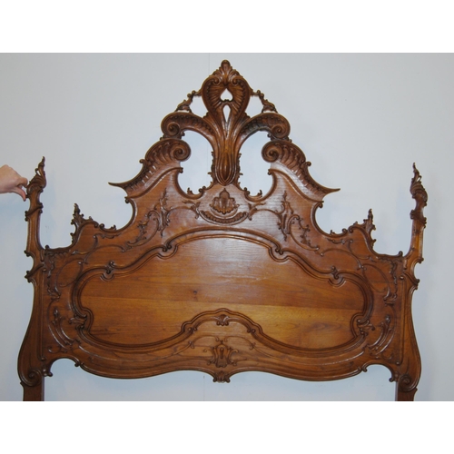 377 - French walnut double bed, the large carved head rest decorated with applied scrolls, with side rails... 