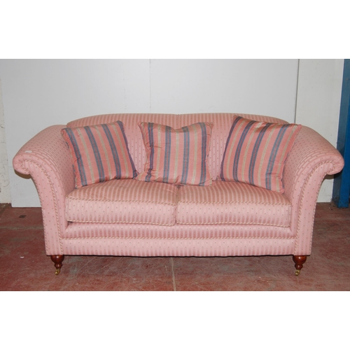 398 - Victorian-style two-seater sofa upholstered in pink moquette, with scatter cushions, on brass castor... 