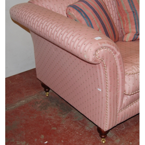 398 - Victorian-style two-seater sofa upholstered in pink moquette, with scatter cushions, on brass castor... 