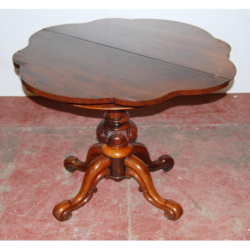 413 - Victorian rosewood tea table with shaped fold-over top, on turned baluster column, quadripartite sup... 