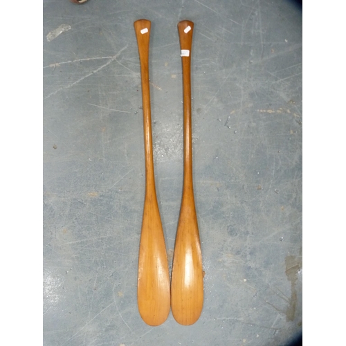 107 - Two wooden paddles, 122cm long approximately.  (2)