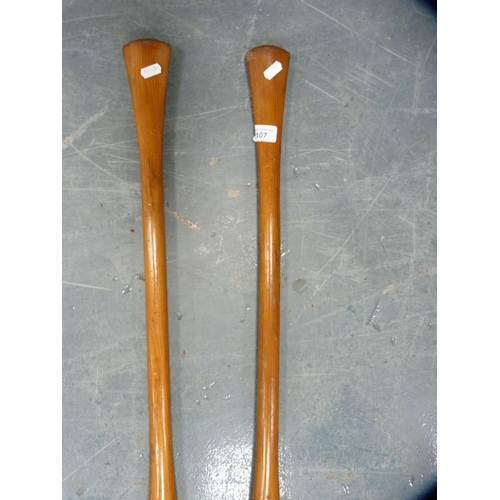 107 - Two wooden paddles, 122cm long approximately.  (2)