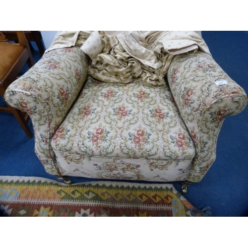 447 - Antique upholstered wing armchair on later brass castors.