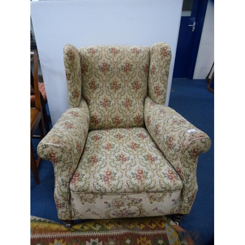 447 - Antique upholstered wing armchair on later brass castors.