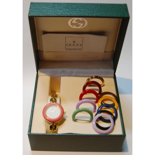 135 - Gucci gold plated lady's bangle wristwatch with ten interchangeable coloured ring bezels, ref no. 11... 