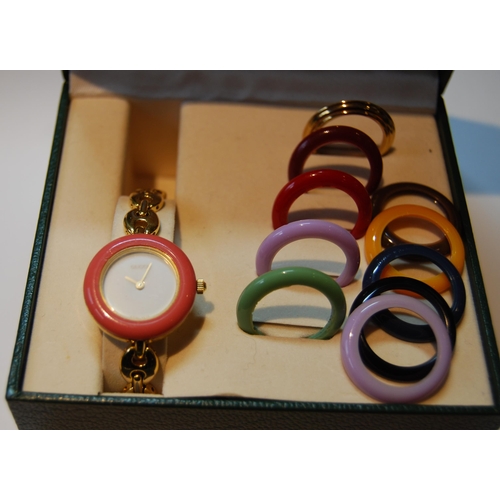 135 - Gucci gold plated lady's bangle wristwatch with ten interchangeable coloured ring bezels, ref no. 11... 