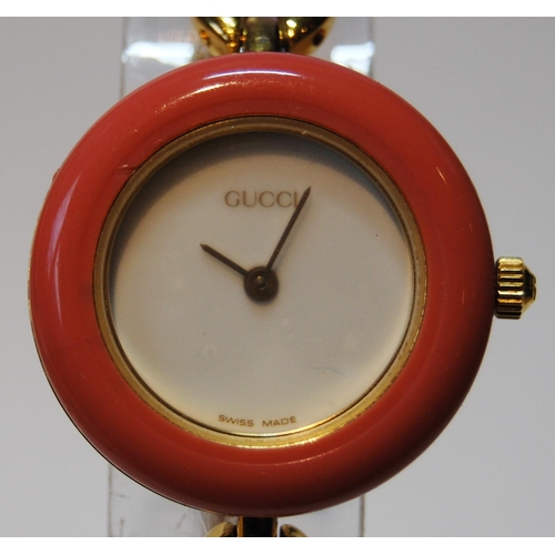 135 - Gucci gold plated lady's bangle wristwatch with ten interchangeable coloured ring bezels, ref no. 11... 