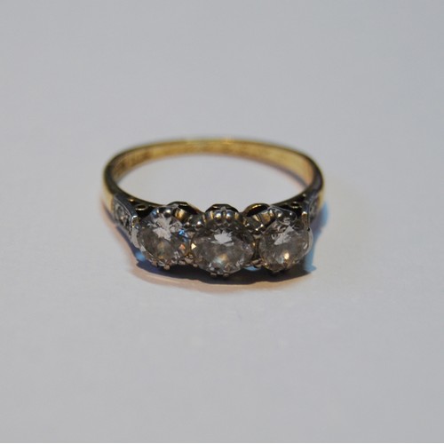 60A - 18ct gold three-stone diamond ring, the central round-cut diamond approximately .5ct flanked by two ... 