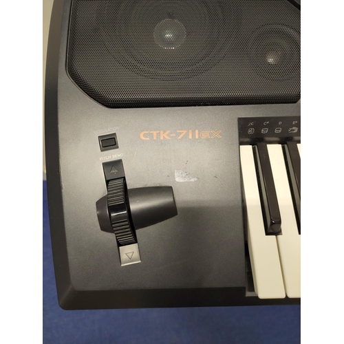 Casio CTK-711 electric keyboard with stand.