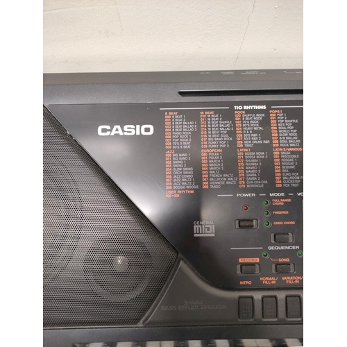 Casio CTK-711 electric keyboard with stand.