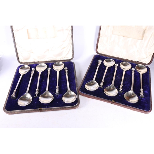 52 - Two cased sets of six white metal serving spoons with apostle terminals.