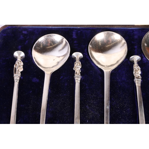 52 - Two cased sets of six white metal serving spoons with apostle terminals.