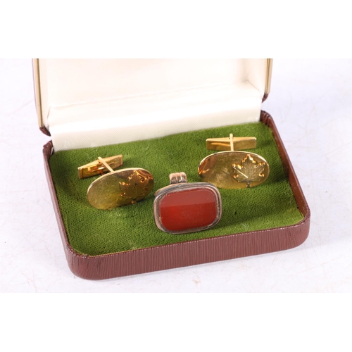 65 - Yellow metal seal fob inset with uncarved carnelian and a pair of Canadain cufflinks.