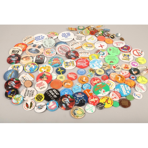 321 - Large collection of novelty and collectible badges to include NATO, Star Wars, Wimpy, Coca-Cola, etc