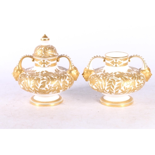 113 - Pair of continental gilt porcelain squat urn vases with mask handles, decorated with foliage, blue i... 