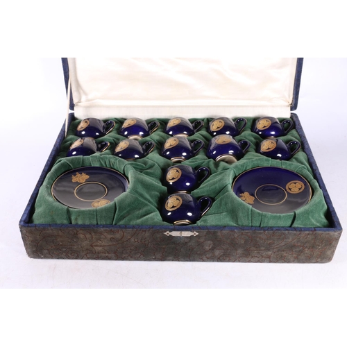 123 - Japanese Satsuma coffee set with Bristol Blue ground and gilt floral decoration in fitted case.