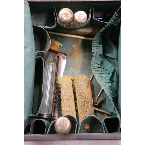 54 - Black leather travelling vanity set with silver topped toilet bottles, silver backed brush, silver h... 