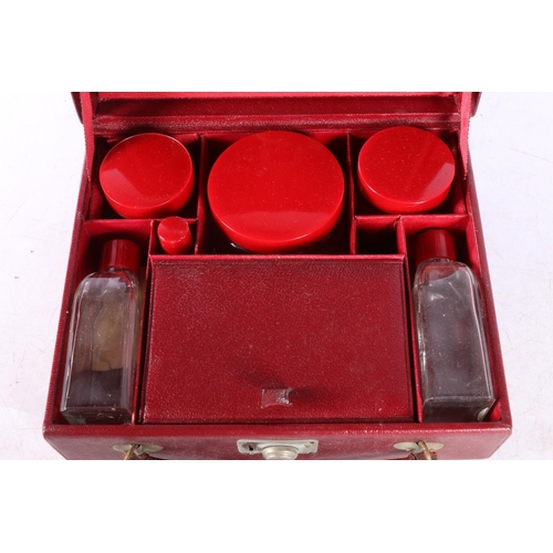 85 - Art Deco style red leather hinge top vanity case, the lid with mirror inset and red plastic topped t... 