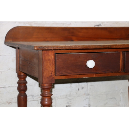 213 - Early 20th century pine side table with two frieze drawers, raised on turned supports, 91cm wide.