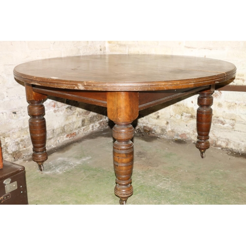 225 - Victorian mahogany extending dining table, raised on turned supports, capped by castors.