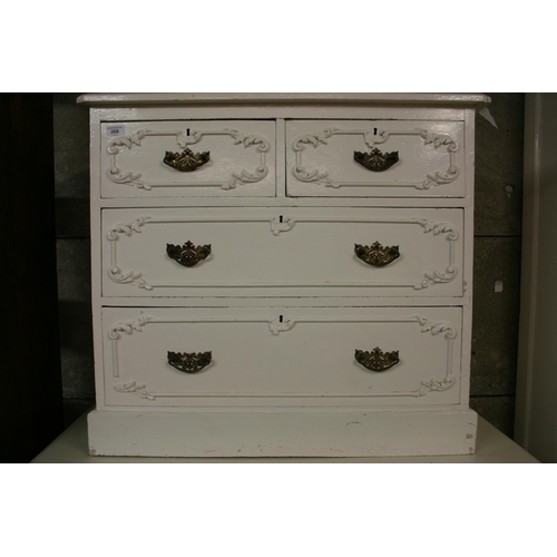 268 - Antique cream painted chest of drawers with applied scrolling foliage sprays, having two short drawe... 