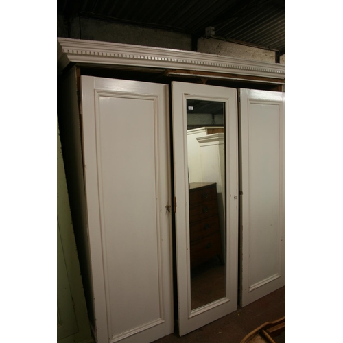 274 - Antique cream painted three door wardrobe, the dentil work cornice above central mirror panel door, ... 