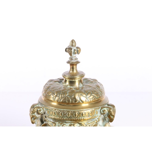 155 - Indian brass inkwell raised on ram mask and dolphin supports, 19cm diameter.