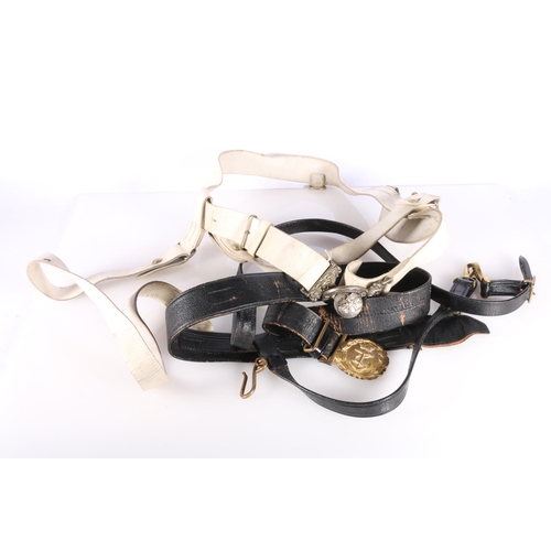 396 - Naval gilded brass belt buckle on black leather belt and a white metal In Defence belt buckle on whi... 