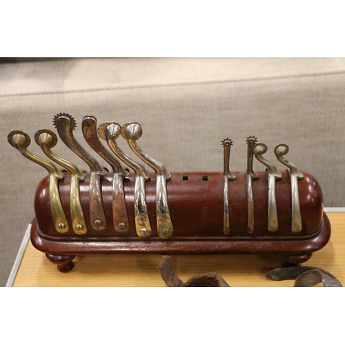 397 - Mahogany spur rack or stand and a group of spurs.