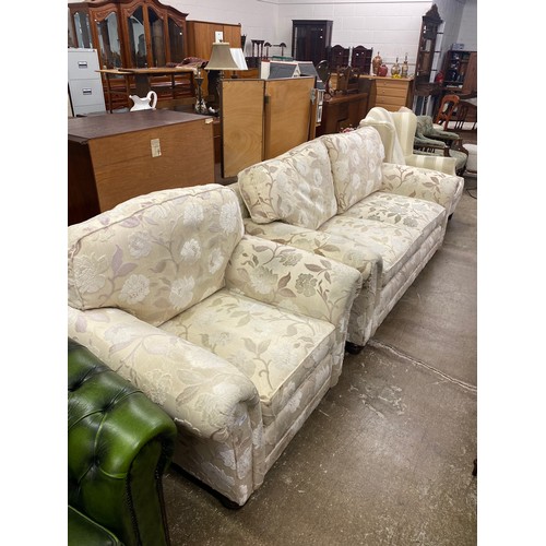 565 - Cream floral two seater, matching arm chair, (2)