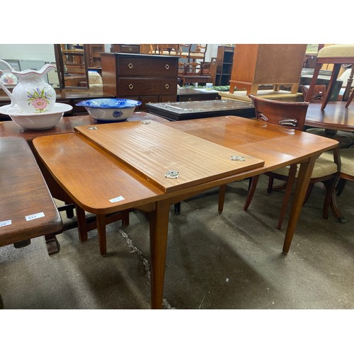 631A - Extending teak mid century dining table with one leaf.