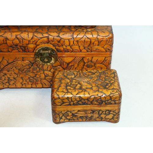 53 - Three graduated heavily carved treen hinge-top boxes depicting birds amongst flowers.